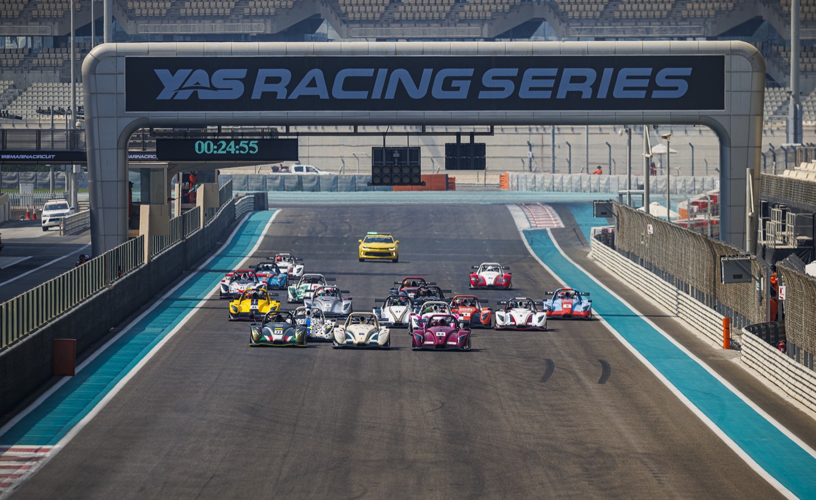 The Gulf Radical Cup field behind the safety car at Yas Marina, under the Yas Racing Series gantry.